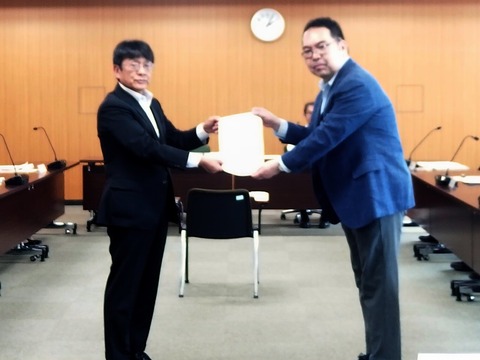 管理者から審議会の会長へ諮問書の手交がなされた様子の写真